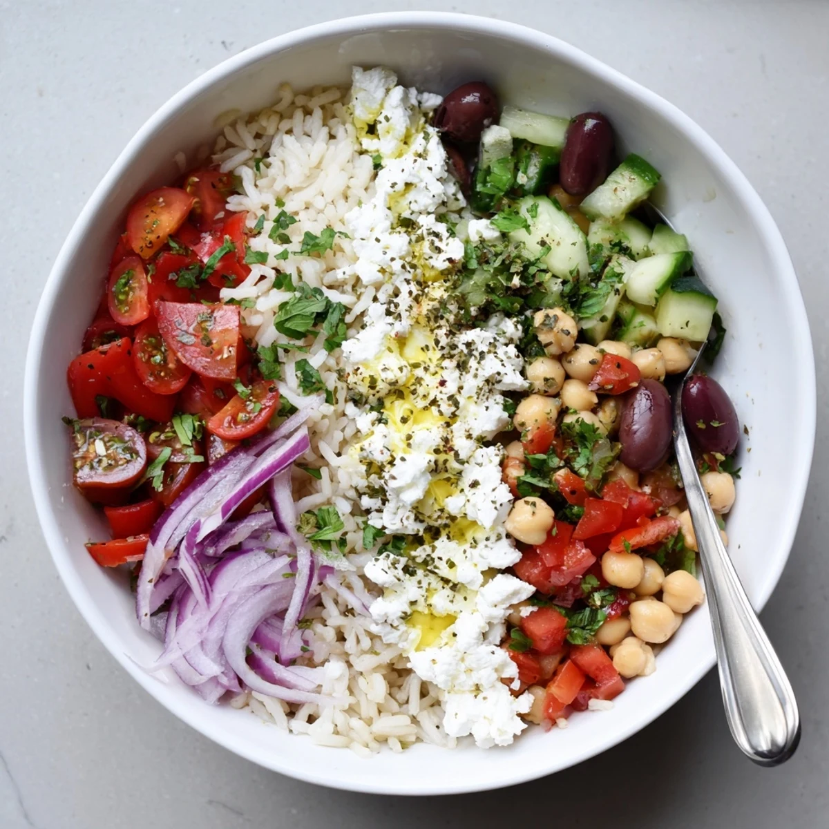 Steaming Mediterranean Rice Bowl drizzled with lemon herb dressing and vibrant chopped vegetables