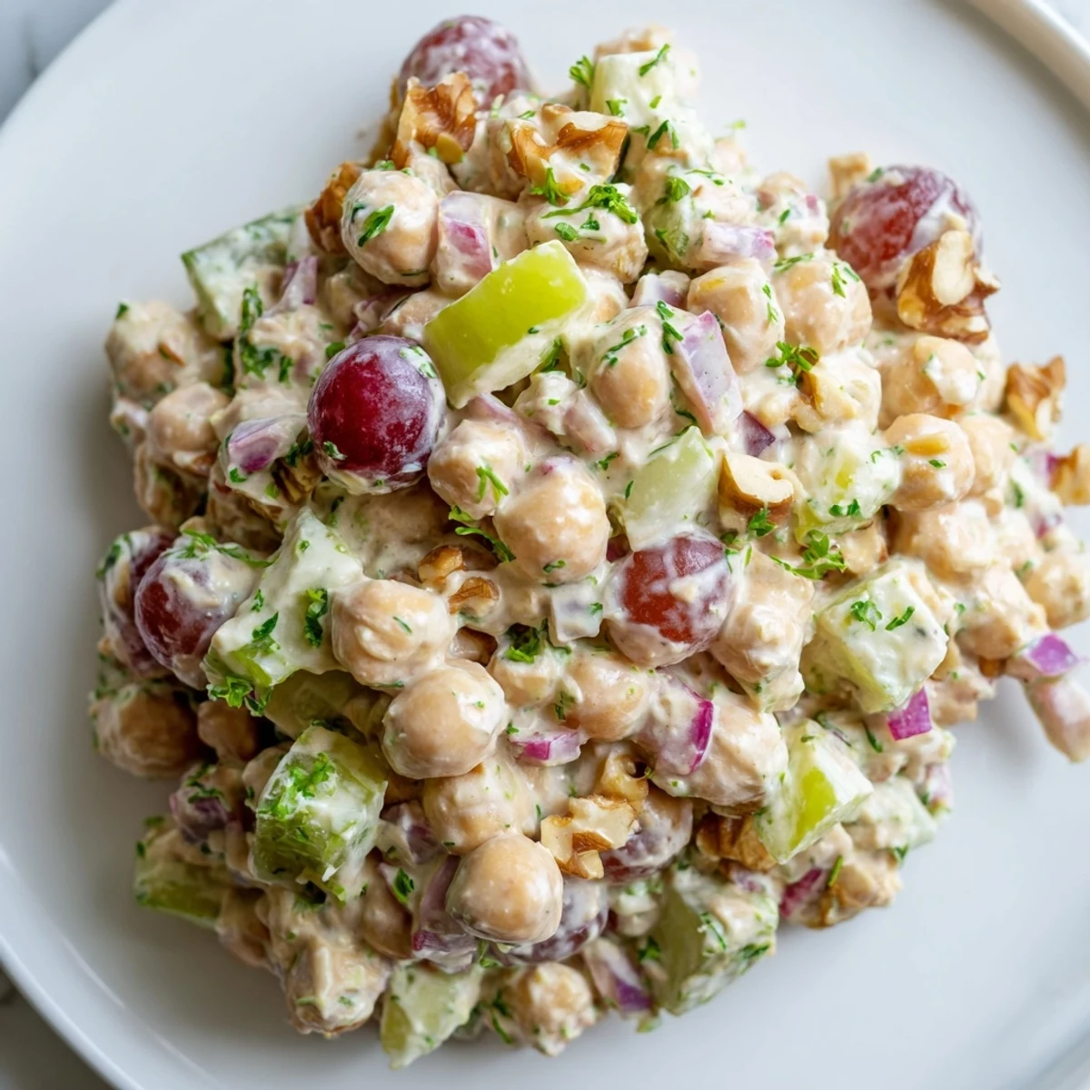 Creamy vegan chicken salad piled on toasted bread with fresh crisp celery and grapes