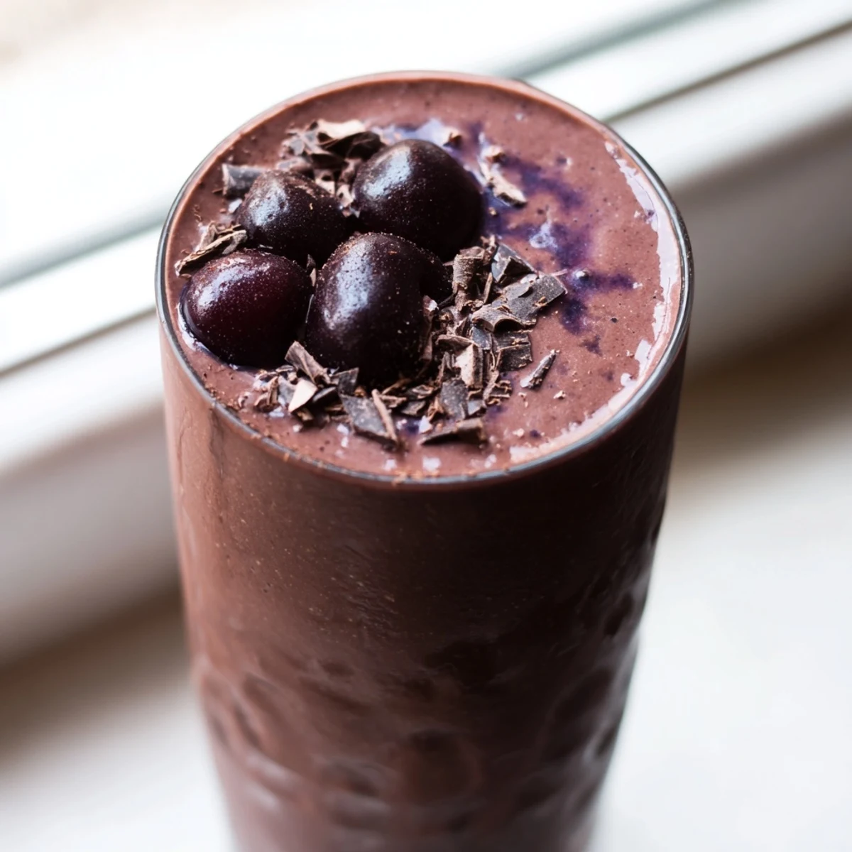 Creamy chocolate cherry protein shake swirled with cocoa and served ice-cold
