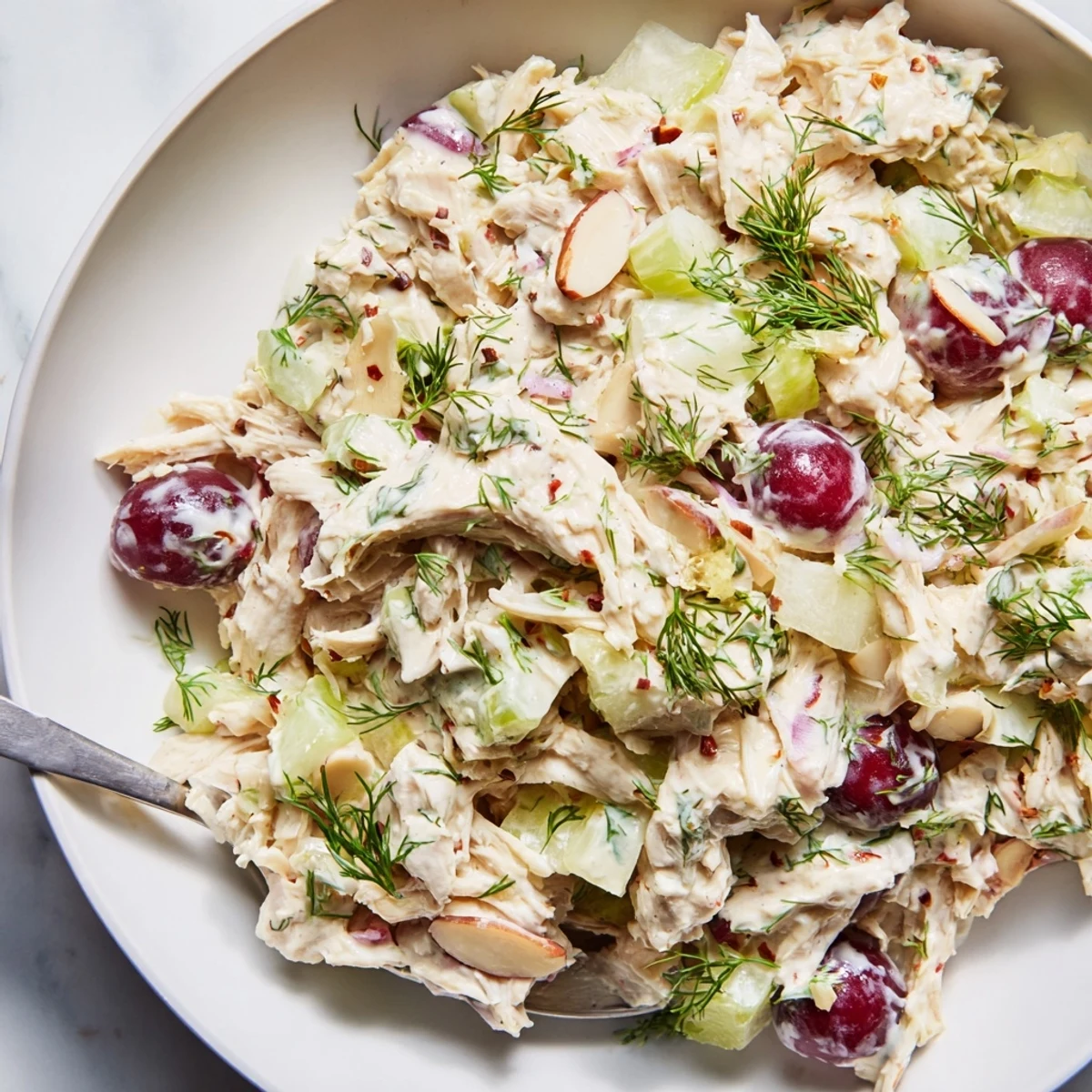 Vegan chicken salad served in a crisp lettuce wrap with juicy red grapes and almonds