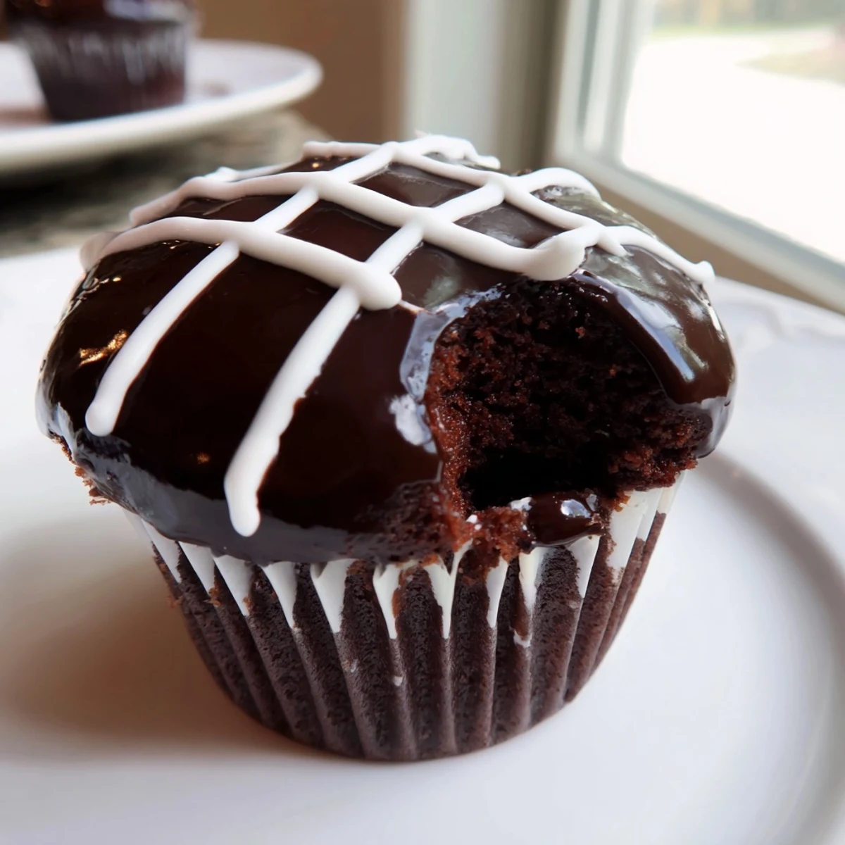 Homemade Hostess Cupcakes with glossy ganache topping and signature white swirl