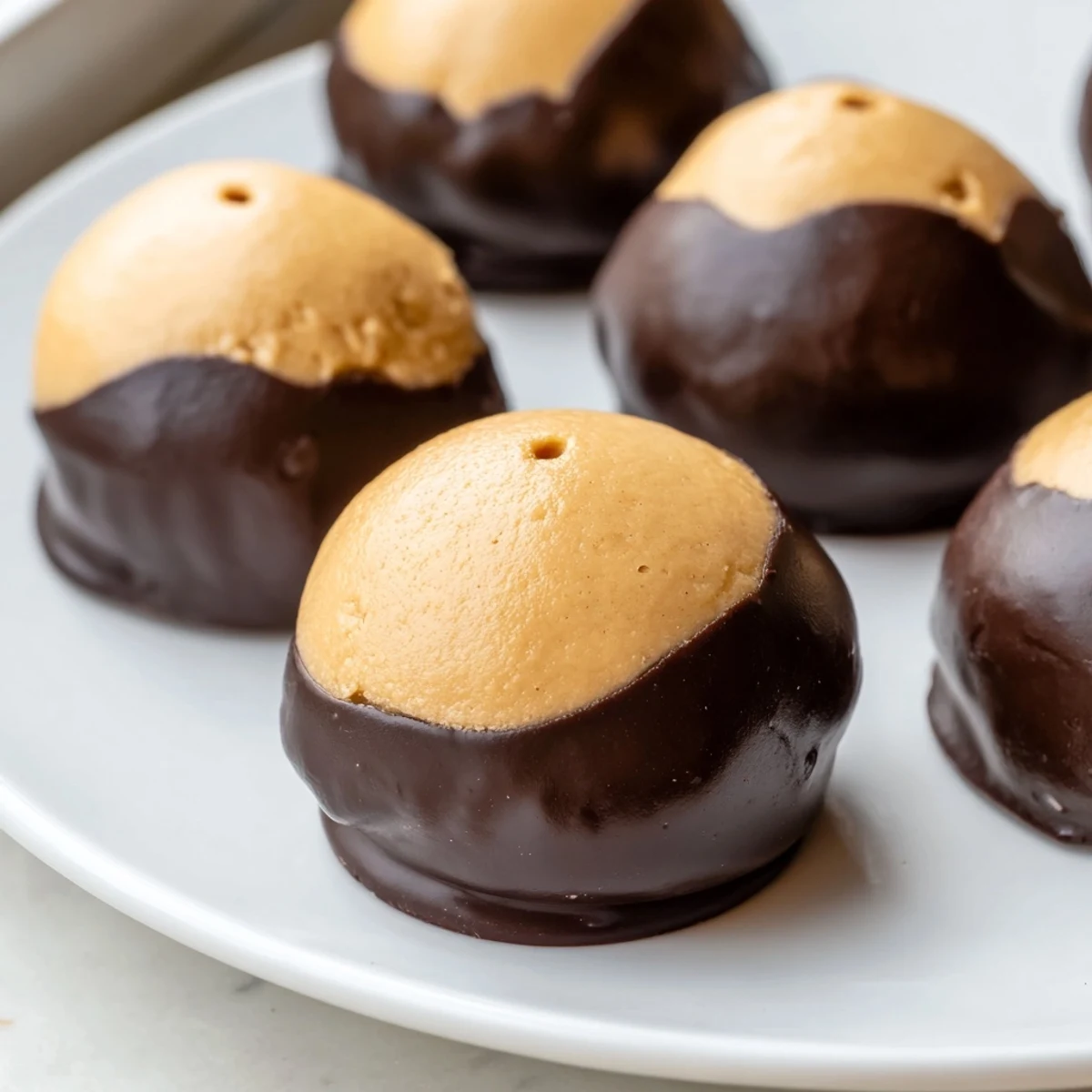 No-bake buckeye cookies arranged on parchment showing smooth peanut butter centers perfectly