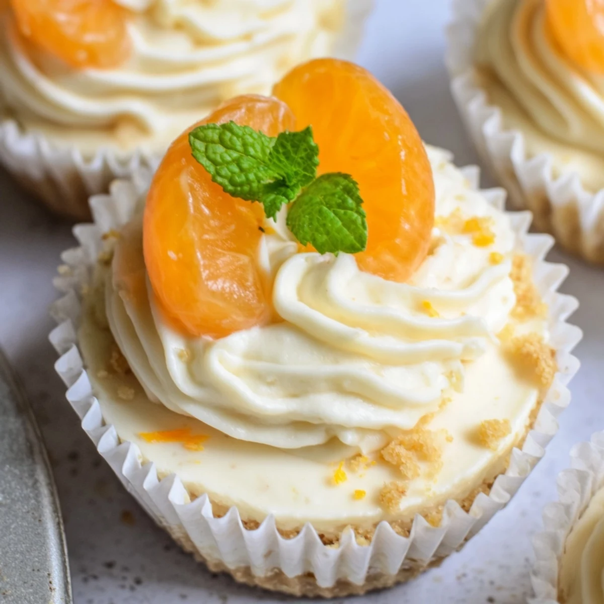 No bake orange cheesecakes in individual portions with whipped cream and vibrant zest