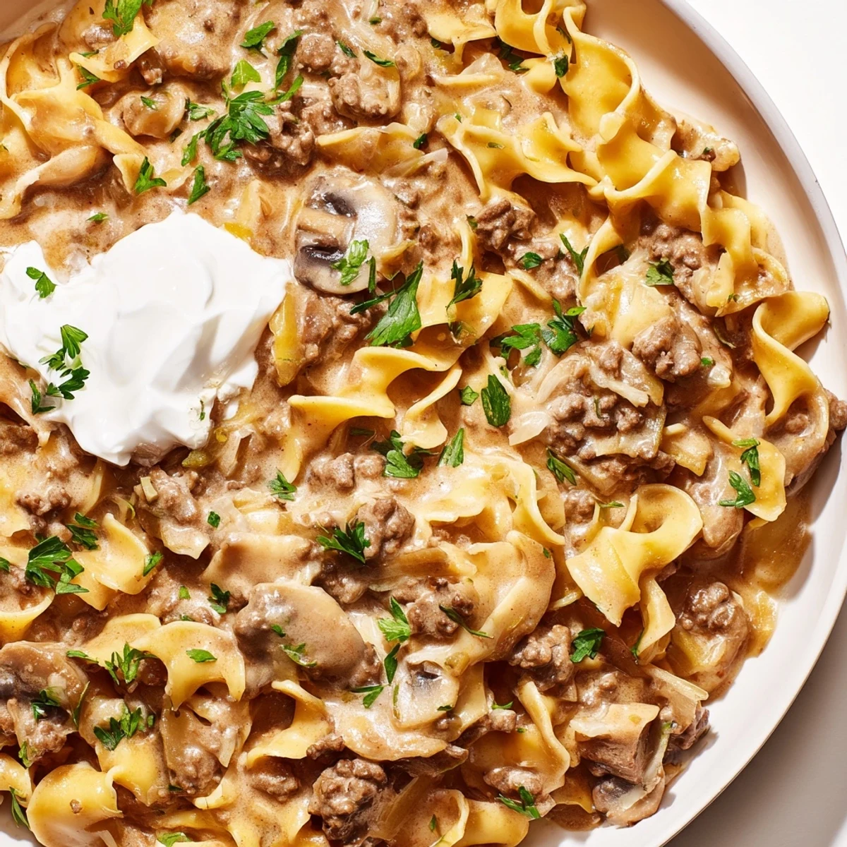 Hearty Hamburger Stroganoff with creamy sauce poured over tender egg noodles