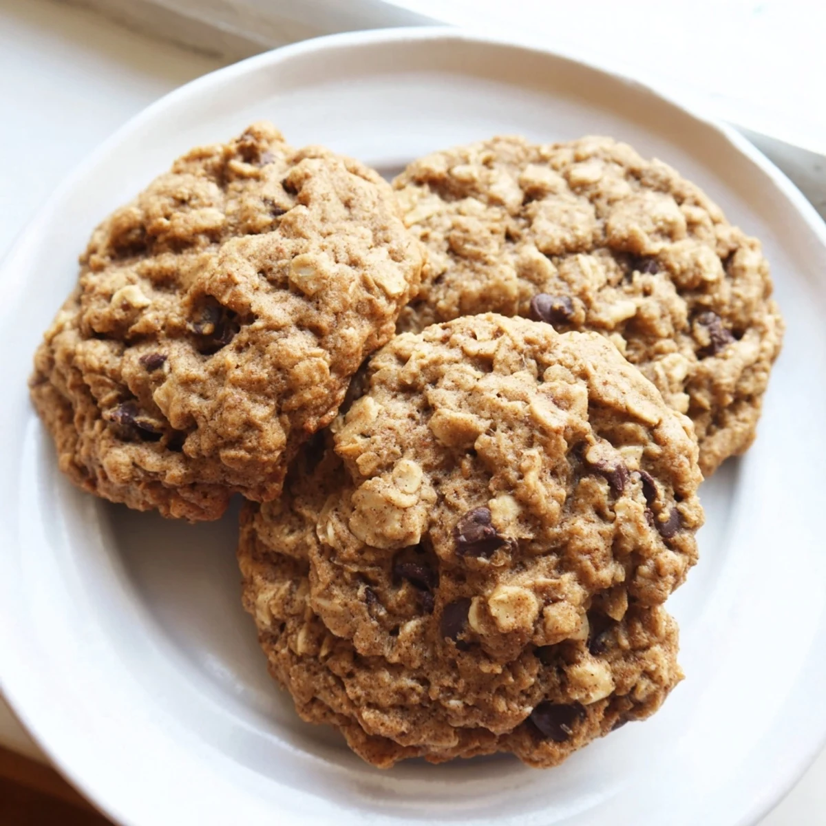 Chewy banana oatmeal cookies with golden edges on a rustic cooling rack