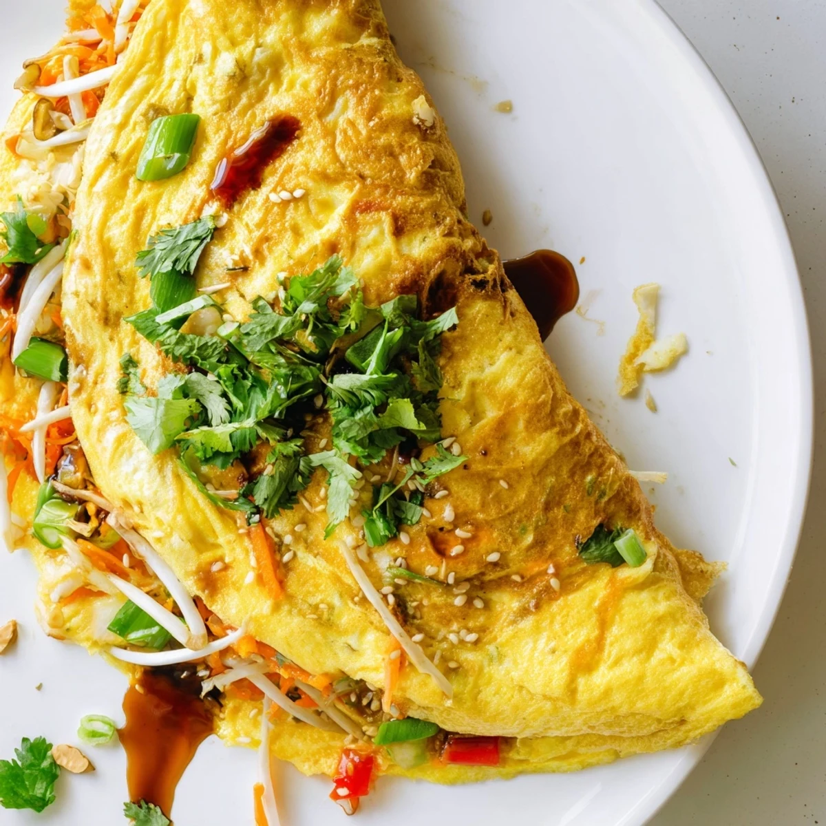 Golden Chinese omelette filled with crisp vegetables and fresh scallions on a white plate