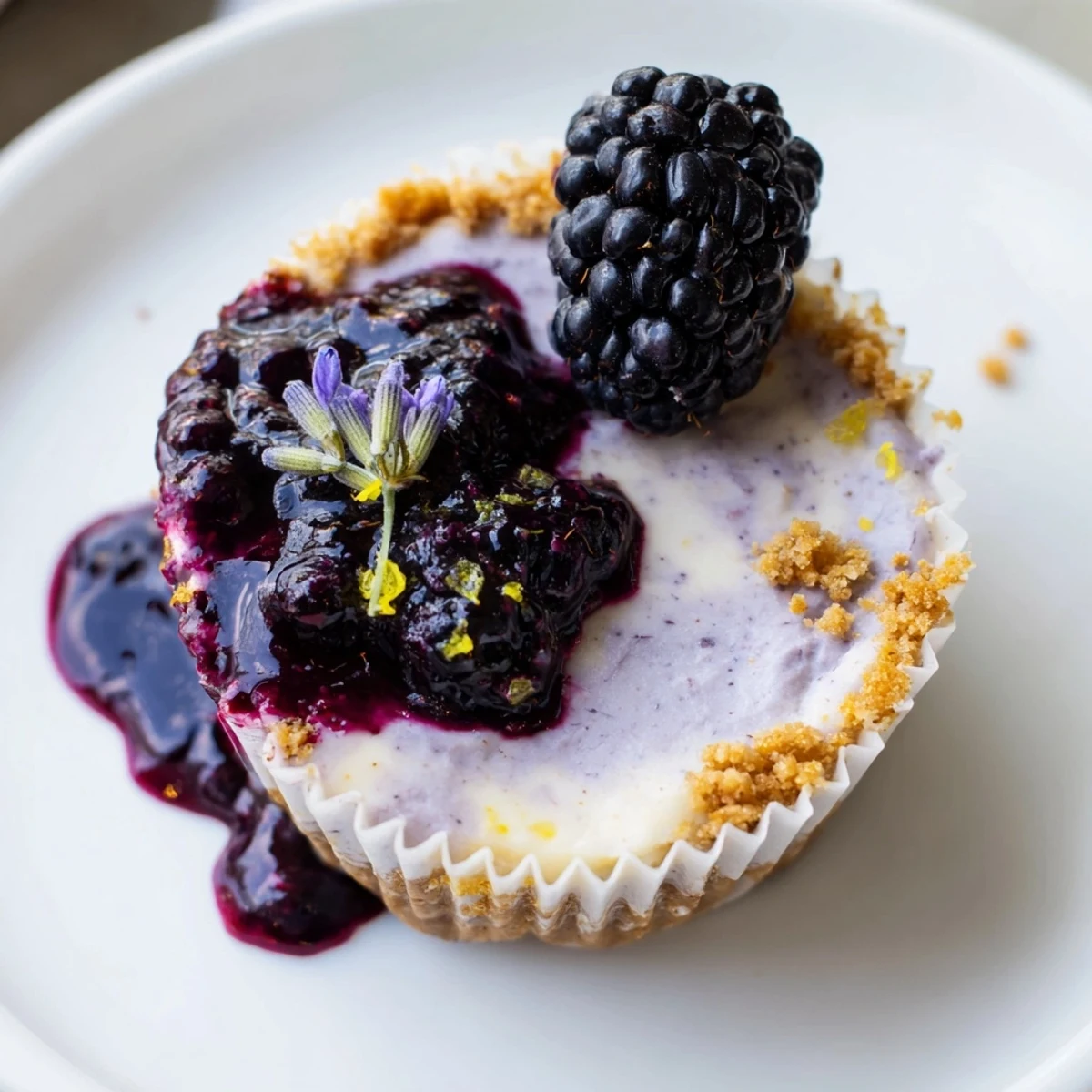 Individual Creamy No Bake Mini Blackberry Lavender Cheesecakes with buttery graham crust and fresh lavender garnish