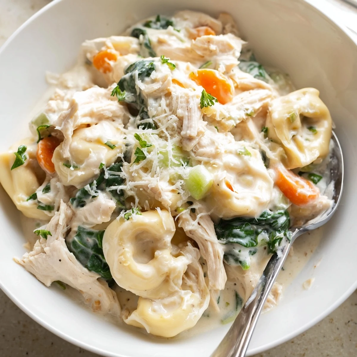 Golden shredded chicken and cheese tortellini swimming in a velvety cream sauce
