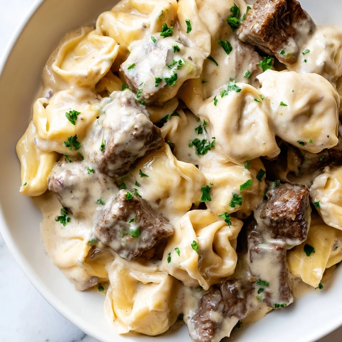 Golden seared steak bites nestled into cheesy garlic steak tortellini draped in a silky cream sauce