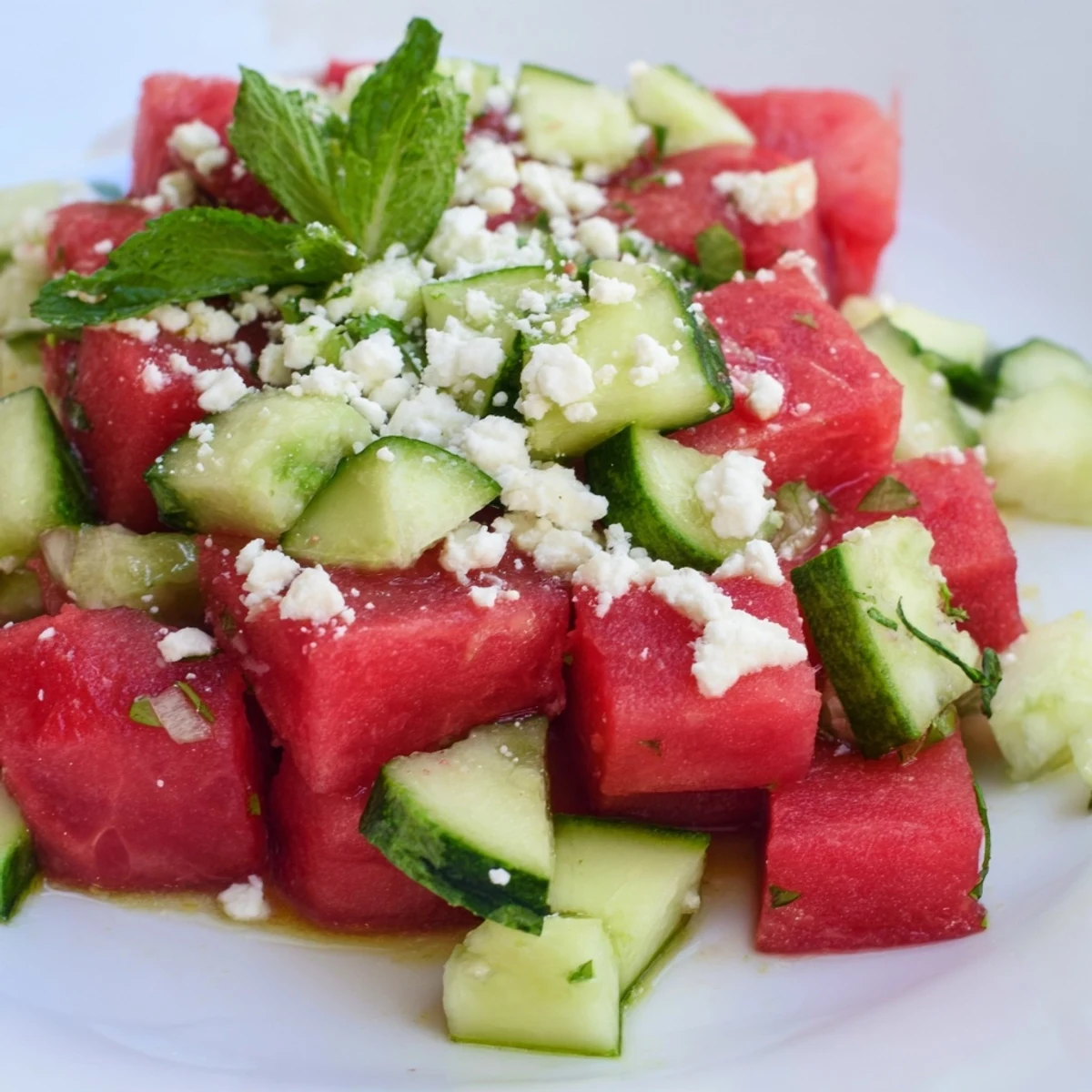 Fresh watermelon cucumber salad with mint and tangy lime dressing in a bowl.  