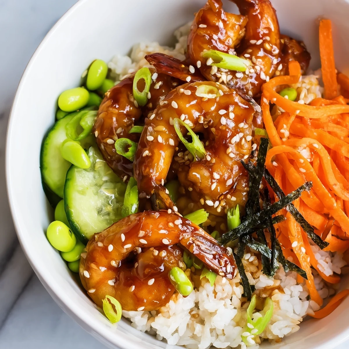 Colorful teriyaki shrimp rice bowl topped with sesame seeds and fresh sliced cucumber  