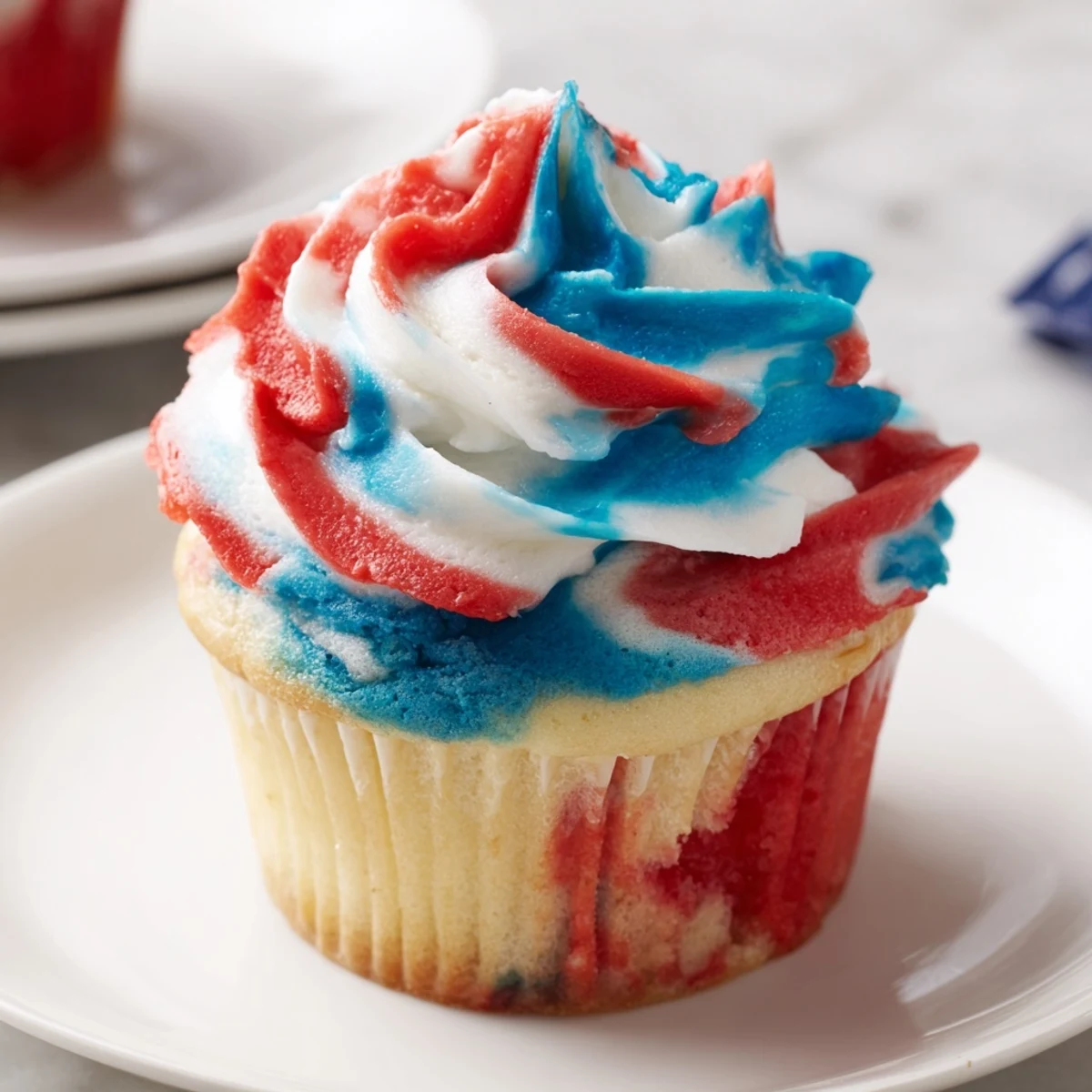 Moist vanilla July Tie Dye Cupcakes featuring patriotic red, white, and blue tie dye swirls.