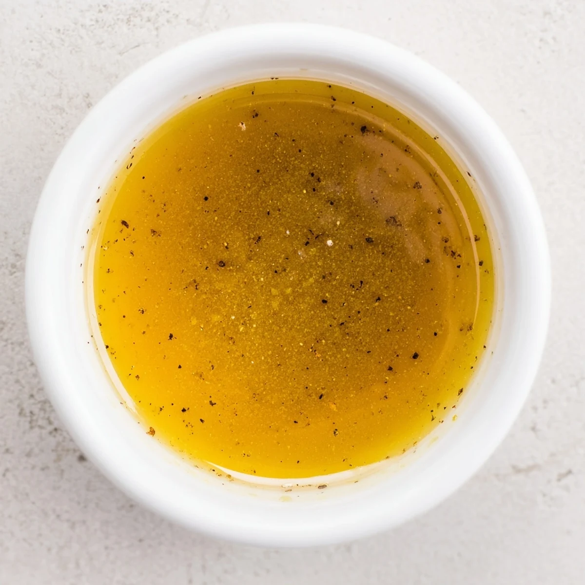 Creamy honey vinaigrette dressing whisked in a glass jar with honey and mustard.  