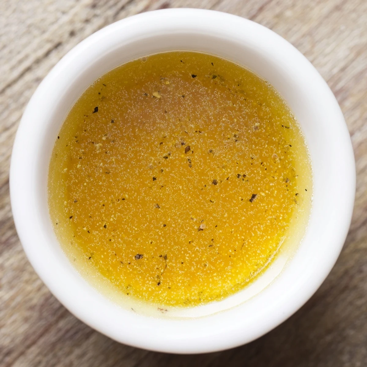 Golden honey vinaigrette drizzled over fresh mixed greens in a bowl.  