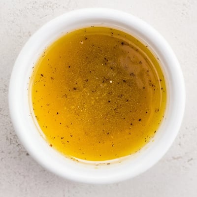 Creamy honey vinaigrette dressing whisked in a glass jar with honey and mustard.  